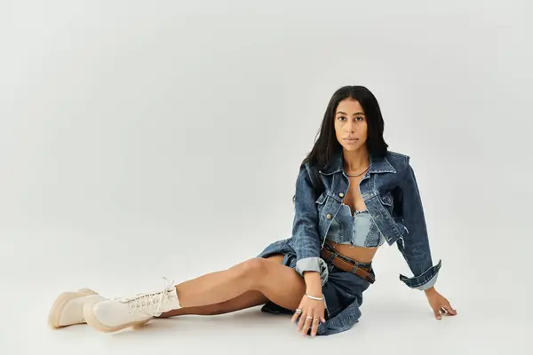 The young woman poses gracefully in stylish denim attire, exuding confidence and charm. — Stock Photo