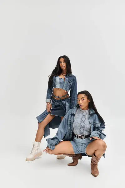 Two fashionable young women display their chic denim styles with confidence and flair. — Stock Photo