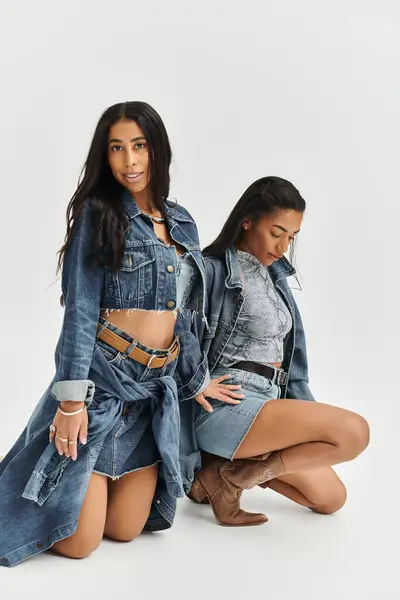 Fashionable young women showcase their trendy denim styles in a creative indoor setting. — Stock Photo