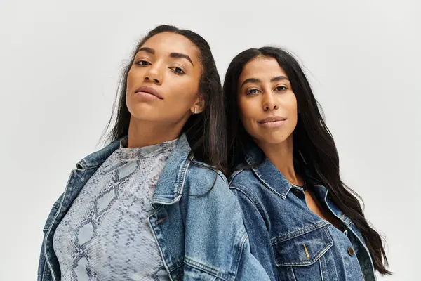 Deux jeunes femmes mettent en valeur leur sens avant-gardiste de la mode, mélangeant des styles décontractés et chics en toute transparence. — Photo de stock