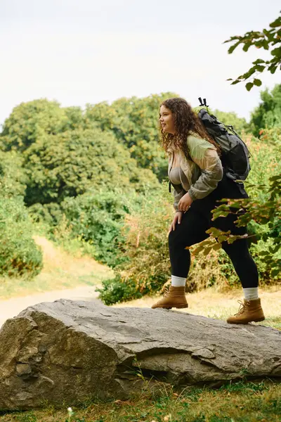 A confident woman enjoys a hiking adventure in a vibrant forest surrounded by nature. — Stock Photo