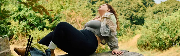 Una donna fiduciosa plus size assapora un momento di pace nella natura, crogiolandosi nel calore dei soli. — Foto stock