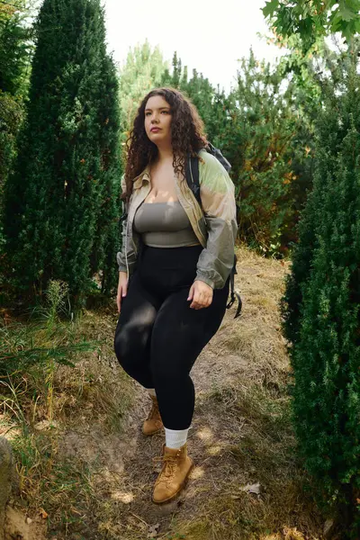 A confident plus size woman enjoys a peaceful stroll among vibrant green trees. — Stock Photo