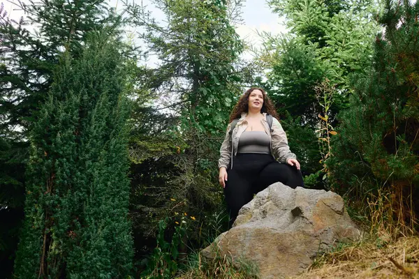 A vibrant plus size woman explores a scenic forest, surrounded by lush greenery and natures beauty. — Stock Photo