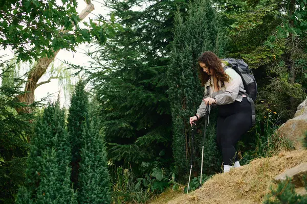 Eine fröhliche Plus-Size-Frau navigiert durch einen lebendigen Wald und umarmt die Ruhe der Natur. — Stockfoto