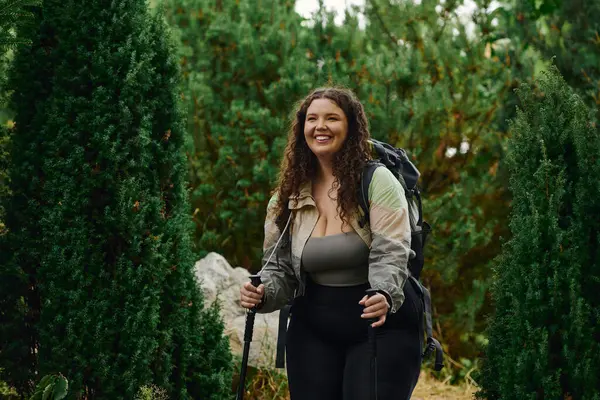 A cheerful plus size woman walks through a lush forest, embracing natures beauty and adventure. — Stock Photo