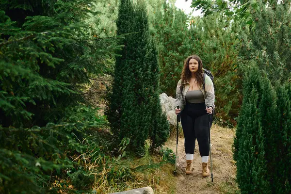 A confident plus size woman walks through a lush green forest, embracing the beauty of nature. — Stock Photo