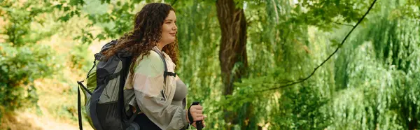 A confident woman embraces the outdoors, surrounded by vibrant greenery in a peaceful forest. — Stock Photo