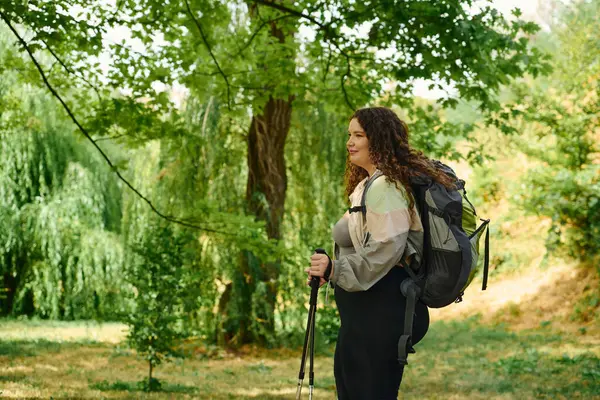 A joyful plus size woman navigates a vibrant forest, embracing the tranquility of nature. — Stock Photo