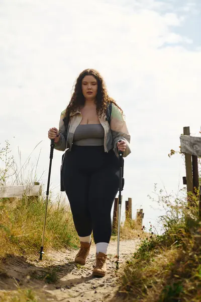 A beautiful plus size woman explores a peaceful path in nature, enjoying her adventure. — Stock Photo