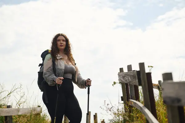 A confident plus size woman walks through a lush field, enjoying the beauty of nature. — Stock Photo