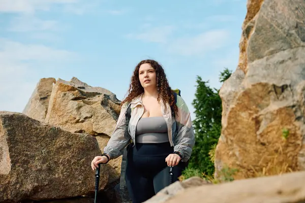 Una impresionante mujer de tamaño grande disfruta de su viaje a través de un hermoso paisaje al aire libre con rocas. — Stock Photo