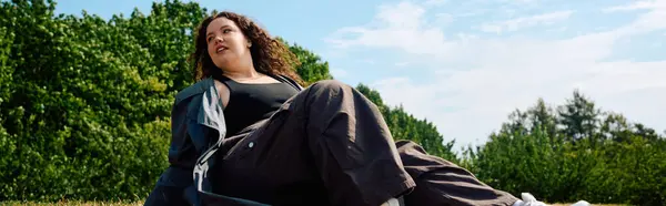 A confident plus size woman lounges peacefully in a vibrant field, enjoying the calmness of nature. — Stock Photo