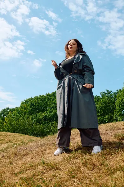 Eine schöne Plus-Size-Frau steht stolz in einem sonnenbeschienenen Feld und umarmt die Schönheit der Natur. — Stockfoto