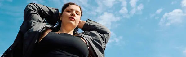 Uma mulher confiante plus size fica em um campo iluminado pelo sol, abraçando a beleza da natureza em torno dela. — Fotografia de Stock