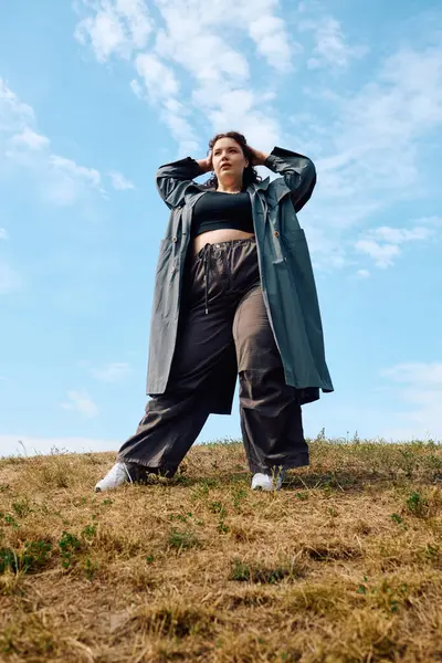 A beautiful plus size woman stands in a sunlit field, embracing nature with confidence. — Stock Photo