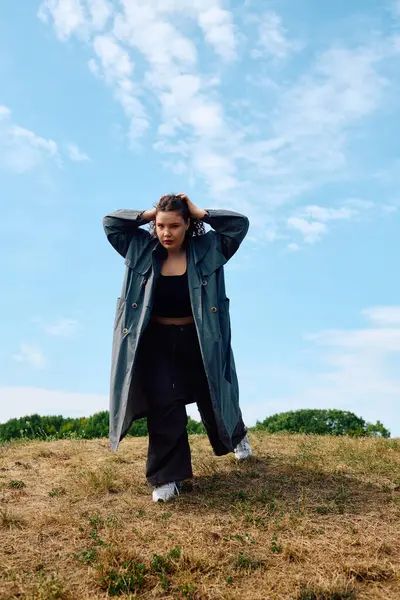 A confident plus size woman strolls through a vibrant field, embracing nature beauty. — Stock Photo