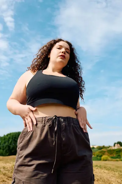 A confident plus size woman stands beautifully amidst a serene natural landscape. — Stock Photo