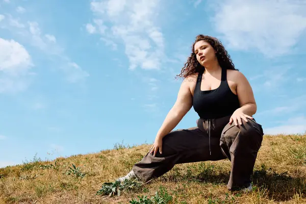 A confident plus size woman enjoys a serene moment in a warm, sunny field. — Stock Photo