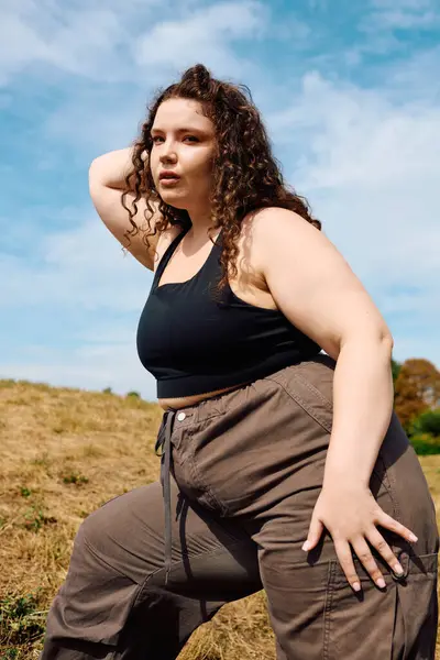 A beautiful plus size woman stands in a field, embracing nature with confidence and poise. — Stock Photo