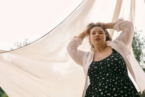 Une femme confiante de plus de taille pose gracieusement dans un champ ensoleillé entouré par la beauté de natures. — Photo de stock