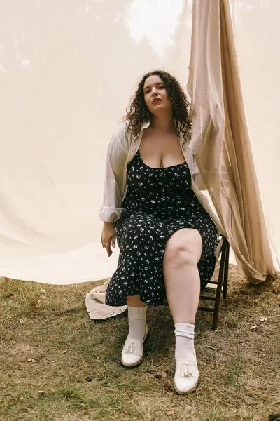 A confident plus size woman sits gracefully in a sunlit field, embracing natures beauty. — Stock Photo