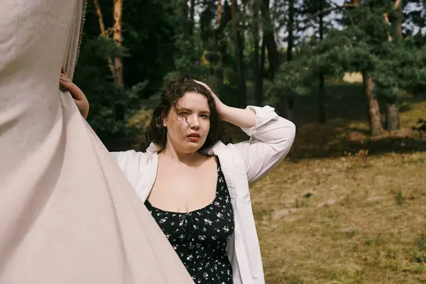 A beautiful plus size woman stands gracefully in a sunlit field, surrounded by nature. — Stock Photo