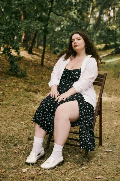 Una donna fiduciosa plus size gode della tranquillità di un campo lussureggiante, abbracciando la bellezza della natura. — Foto stock