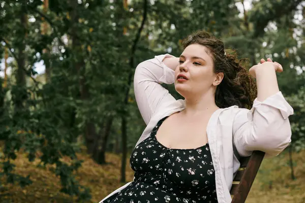 Una bella donna plus size assapora la tranquillità di un campo nella natura. — Foto stock