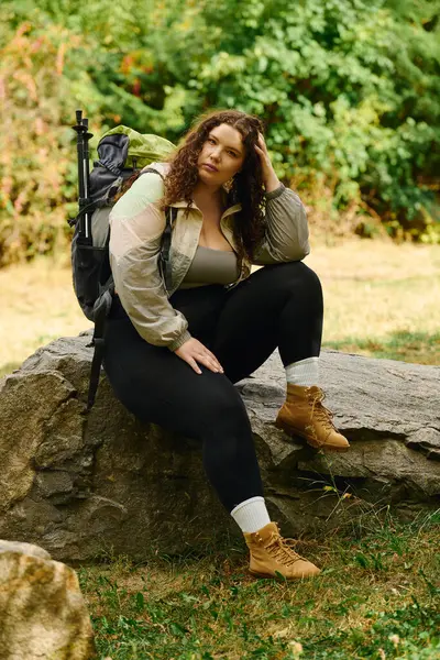 The beautiful plus size woman relaxes on a rock surrounded by lush greenery, embracing tranquility. — Stock Photo