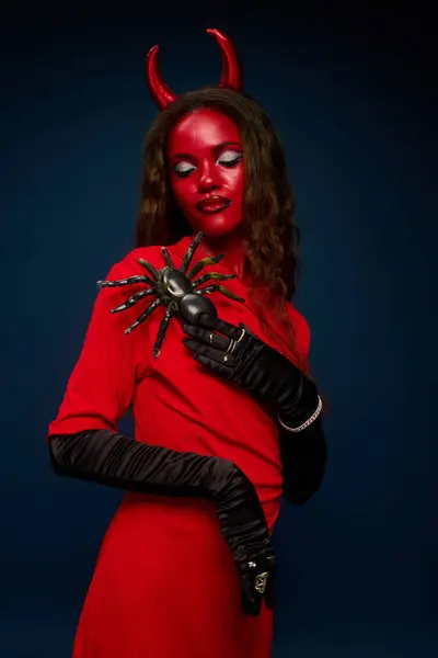A captivating woman in a red devil costume poses confidently, showcasing her spooky allure. — Stock Photo