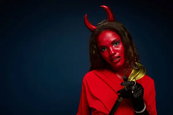 A striking woman celebrates Halloween, adorned in a devil costume, exuding charm and intrigue. — Stock Photo