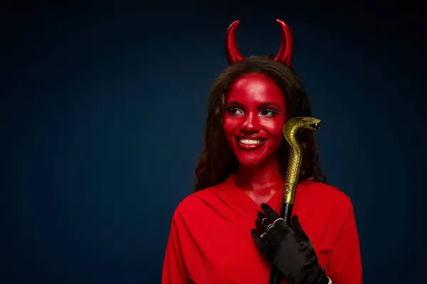 A gorgeous woman in a devil costume smiles happily. — Stock Photo