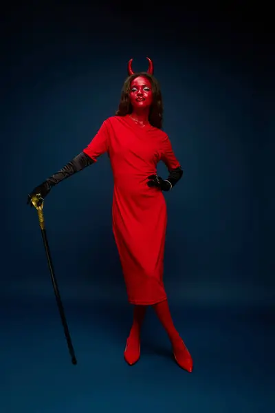 This captivating figure features a striking devil costume in vibrant red tones. — Stock Photo