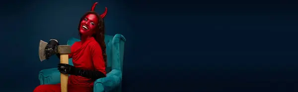Dressed in red with devil horns, the confident woman embraces the Halloween spirit in style. — Stock Photo