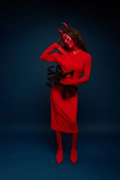 A captivating woman dressed in a striking red devil outfit showcases her creativity for Halloween. — Stock Photo