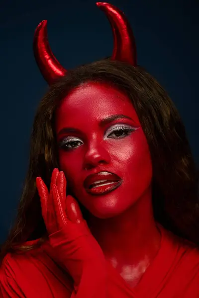 This captivating woman showcases a stunning red Halloween outfit, embodying a devilish allure. — Stock Photo
