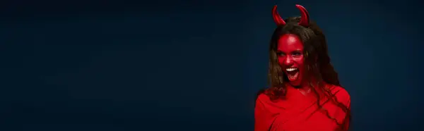A cheerful woman dressed in a striking red devil costume brings Halloween spirit to life. — Stock Photo