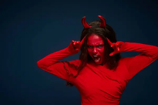 A captivating woman dressed as a devil passionately expresses excitement for Halloween. — Stock Photo