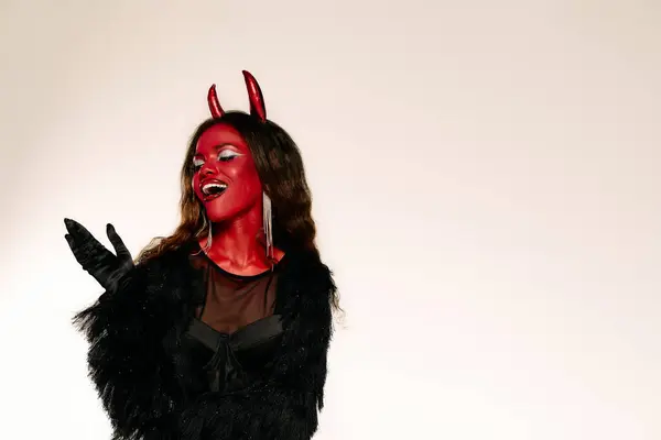 The beautiful woman dressed as a devil shows off her playful spirit and vibrant costume. — Stock Photo