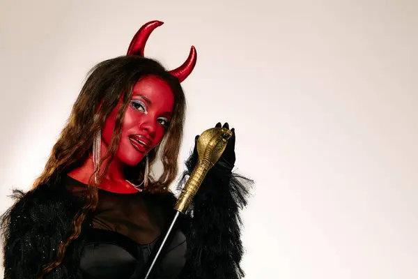 Una splendida donna celebra Halloween in un audace e colorato costume da diavolo. — Foto stock