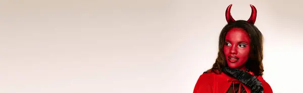 This enchanting woman showcases her Halloween spirit in a bold devil costume, exuding creativity. — Stock Photo