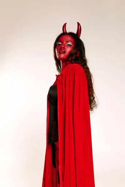 Una splendida donna in rosso con le corna del diavolo mostra il suo spirito di Halloween in un evento festivo. — Stock Photo