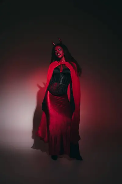 The enchanting woman, adorned in red and black, captivates the night in her Halloween ensemble. — Stock Photo