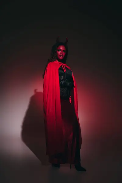 Uma mulher cativante exibe elegância em um traje de Halloween vermelho impressionante. — Fotografia de Stock