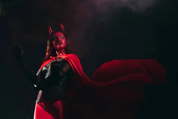 A stunning woman in a devil costume poses, radiating Halloween spirit. — Stock Photo
