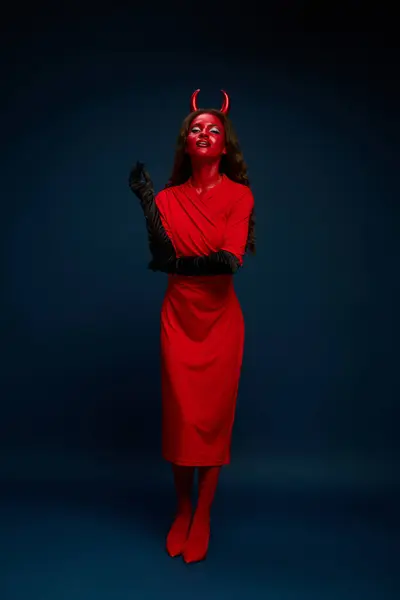 A stunning woman showcases her bold red Halloween costume, embodying a playful yet fierce spirit. — Stock Photo