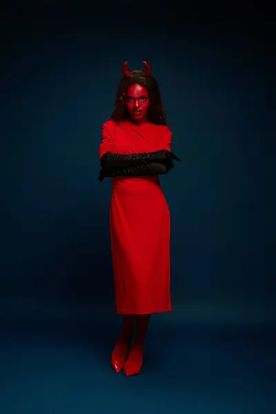 Dressed in a bold red devil costume, she embodies Halloween spirit with a fierce look. — Stock Photo