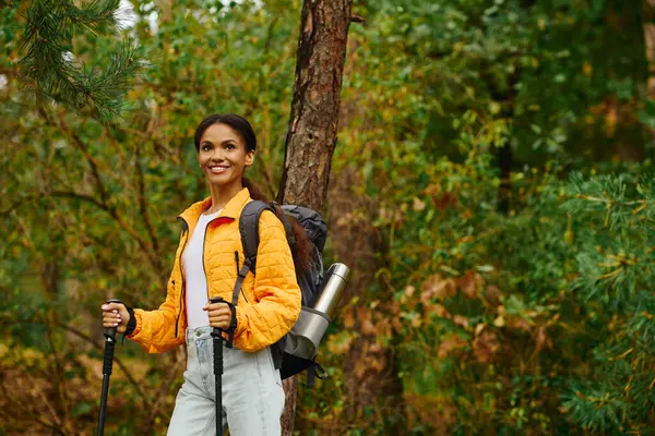 Under the golden hues of autumn, a young woman smiles as she explores the serene forest trails. — Stock Photo