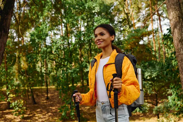 A young woman hikes through a beautiful autumn forest, surrounded by colorful trees and fresh air. — Stock Photo